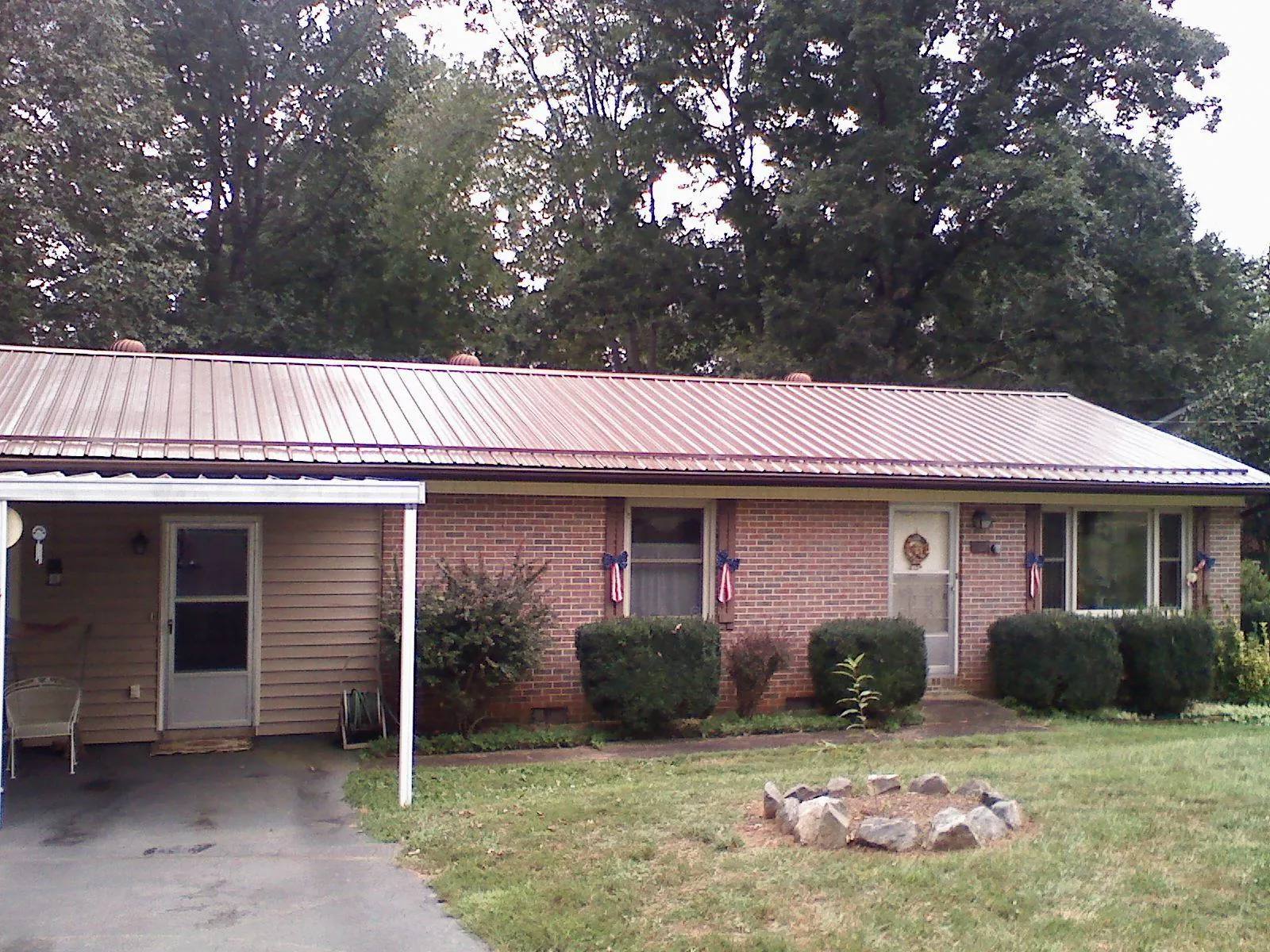 Bronze metal roof and carport on a brick ranch home — Roof Repair work by our crew in Marion